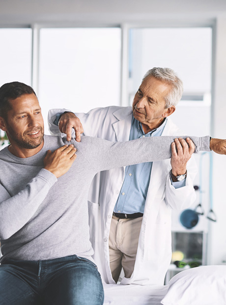 Healthcare professional assisting patient with arm movement