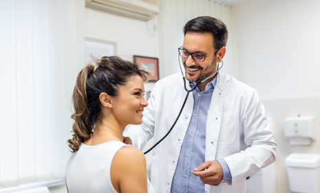 Doctor using stethoscope during patient exam