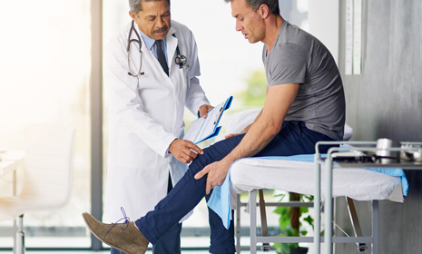 Doctor examining patient’s injured leg